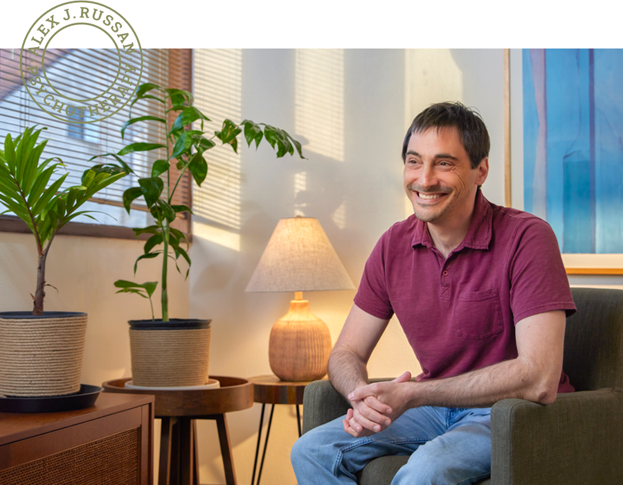 Portrait of Alex J. Russan, a psychotherapist based in California, sitting in his office